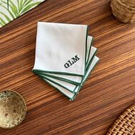 white handkerchief with green monogram and rolled hem