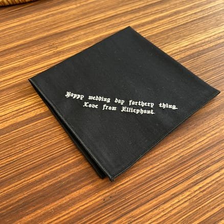 black handkerchief with embroidered message